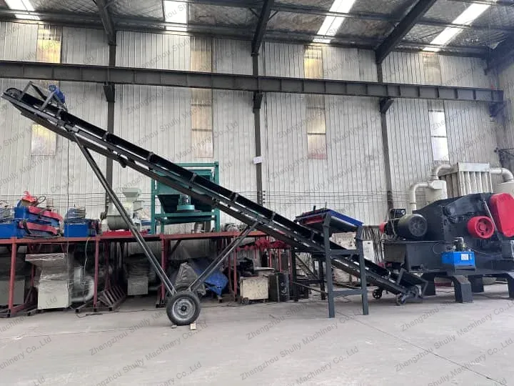 Conveyor for waste pallet crusher
